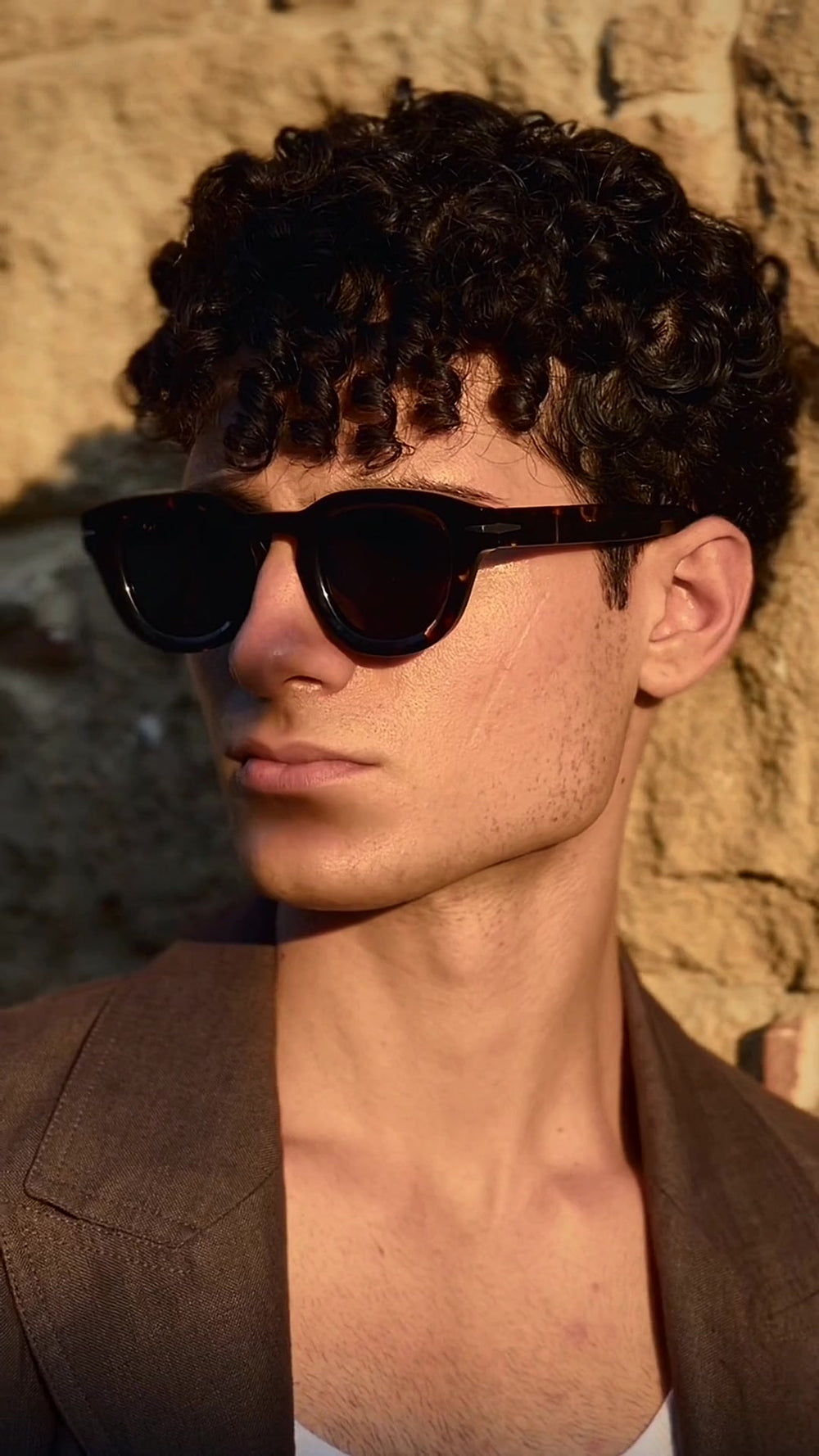 Mann mit Moncada Sonnenbrille in Havanna vor einer sizilianischen Steinmauer